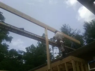 Carpenter setting a ridge beam over a new addition frame — Ice Dam Removal by Roofing Brothers in Ashtabula