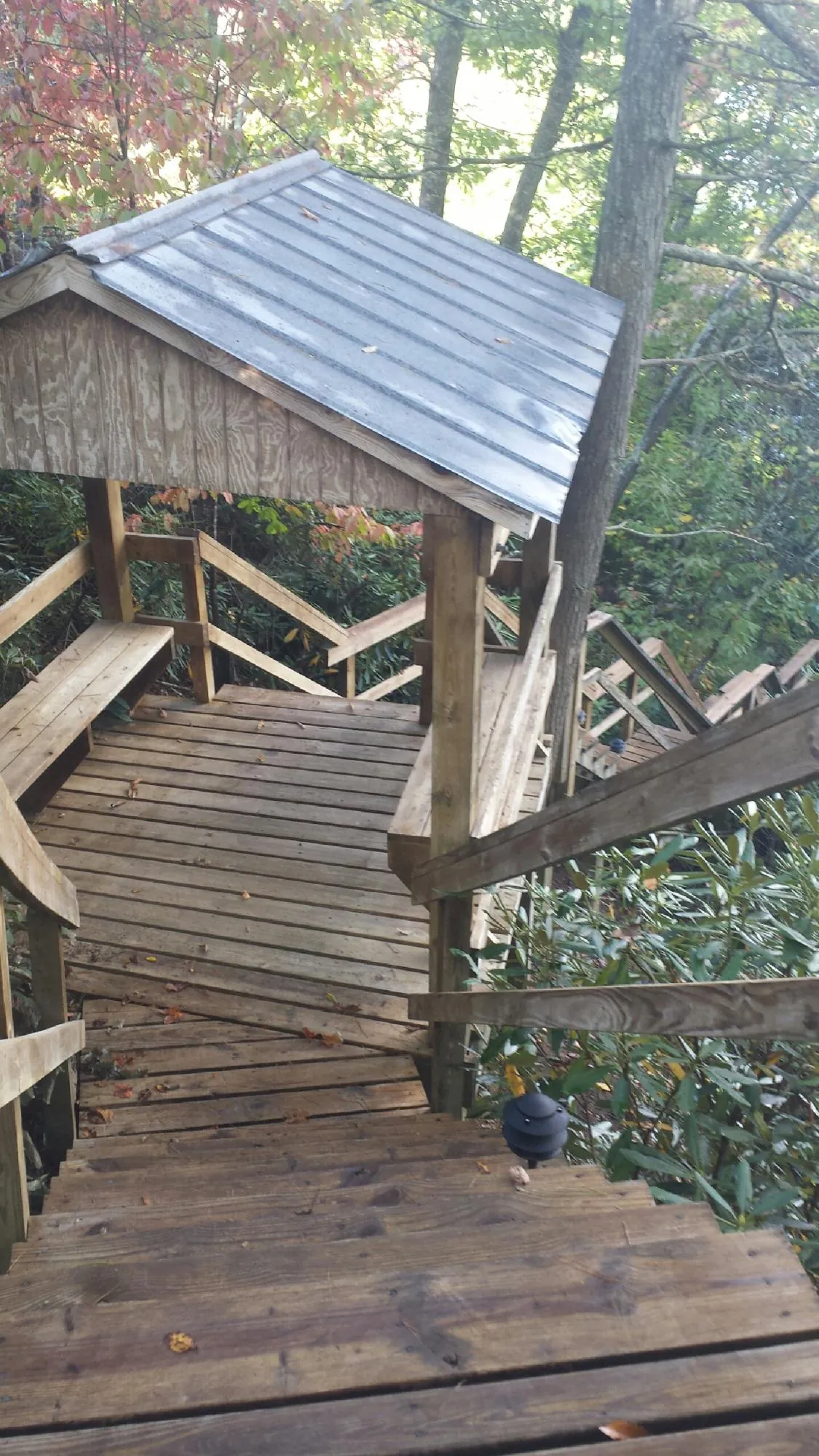 Metal roofed shelter over wooden steps on a wooded walkway — Skylight Repair & Installation work by our crew in Ashtabula