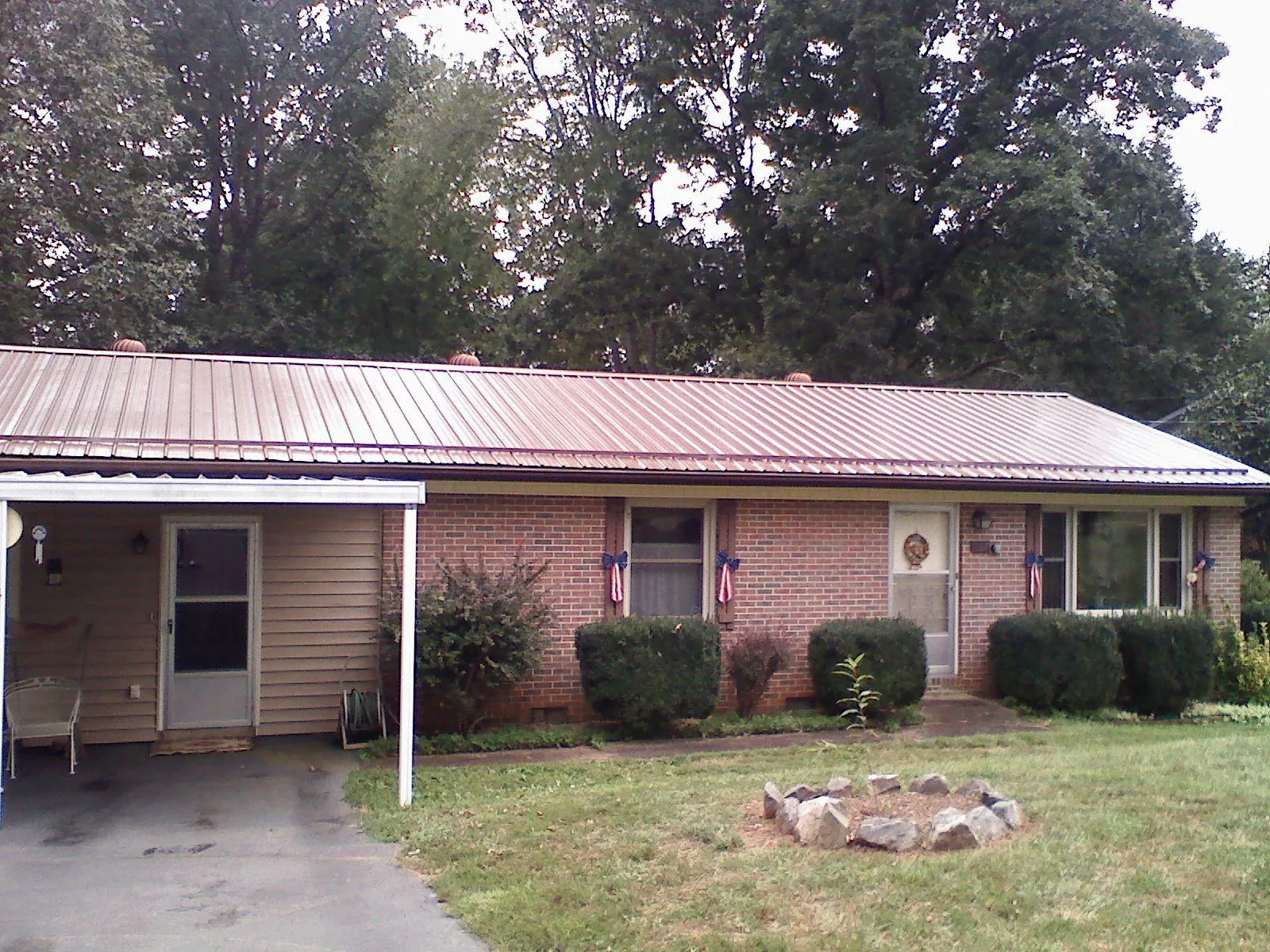 Bronze metal roof and carport on a brick ranch home — Roof Repair work by our crew in Ashtabula
